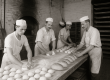 Black-and-white photo of early 20th-century bakers in a Pittsburgh bakery kneading dough and baking loaves, representing Mancini’s humble beginnings.