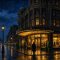 Illustration of a downtown Pittsburgh department store at night with its marquee lit and a streetcar passing on a wet street
